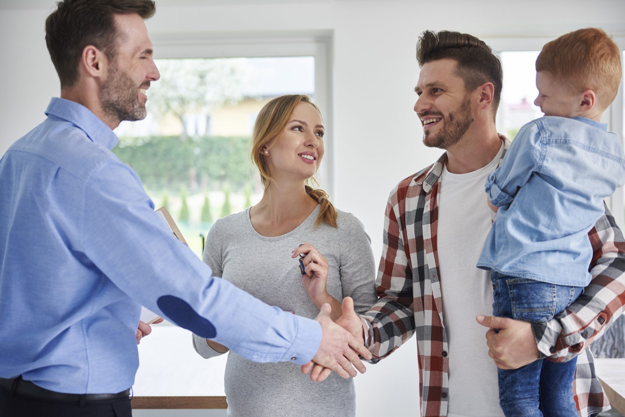 Family and real estate agent shaking hands having deals